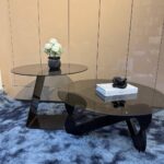 Table basse ronde et table d’appoint en verre fumé sur un tapis
