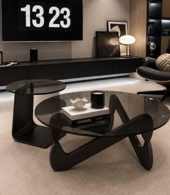 Ensemble table basse ronde et table d’appoint en verre fumé avec piètement noir dans un salon