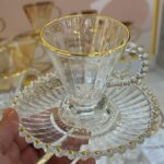 Tasse en verre strié avec sous-tasse à bord perlé doré et anse perlée