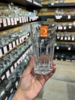 Verre droit à facettes en verre transparent tenu en main