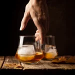 Deux verres tumbler transparents à base évasée sur une table en bois